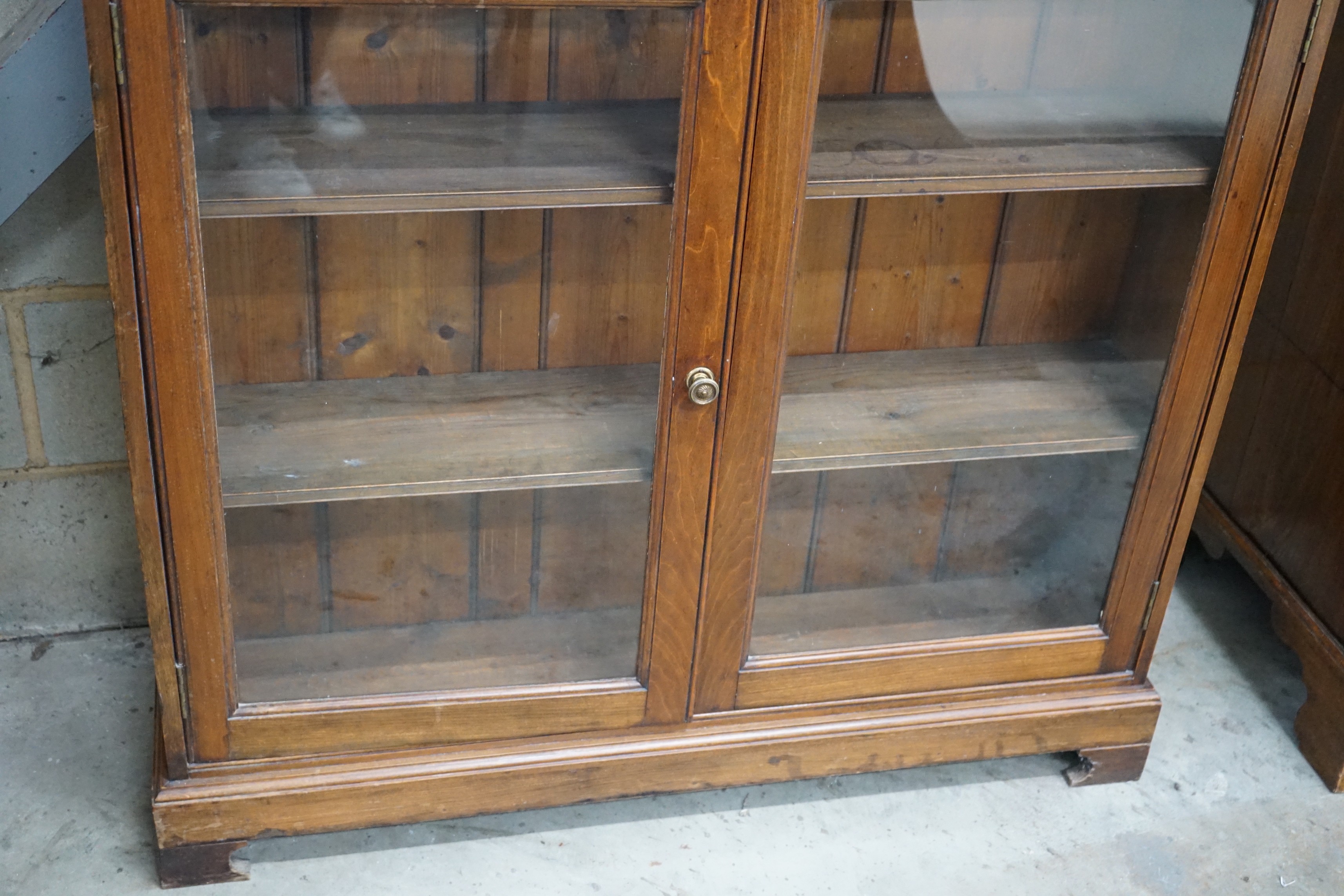 A Victorian style glazed walnut bookcase width 110cms, depth 26cms, height 136cms.